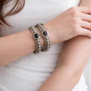 Two silver beaded bangles with black stones.