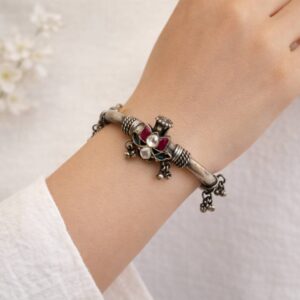 Silver kada with floral stone centerpiece.