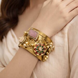 Wide gold cuff with pink stone and floral enamel charms.