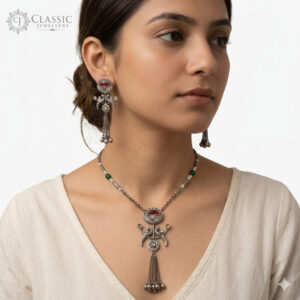 Model wear Handcrafted oxidized silver jewelry set featuring a peacock motif pendant with ghungroo tassels and matching drop earrings on a white background.