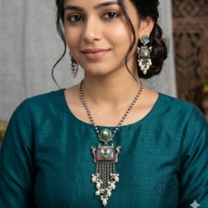 A matching set of vintage-style oxidized silver-tone jewelry, including a pendant necklace and two drop earrings, featuring pink rectangular quartz, green emerald studs, multi-colored gemstone embellishments, and white pearl clusters