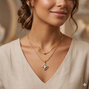 A model wearing a two-layer anti turnish snake chain necklace featuring a simple gold bead and a square geometric crystal pendant.