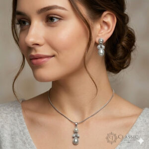 Model wear A matching jewellery set featuring a sterling silver snake chain necklace with a pear-shaped pearl pendant and coordinating drop earrings