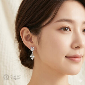 Model wearing silver clover-shaped stud earrings with a triple pearl dangle and anti-tarnish finish by Classicjewellery
