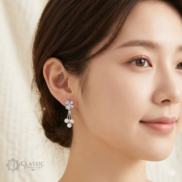 Model wearing silver clover-shaped stud earrings with a triple pearl dangle and anti-tarnish finish by Classicjewellery