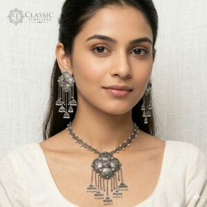 A detailed photo of an intricate German silver tribal-style necklace and matching tassel earrings.