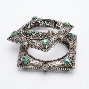 Close-up of two stacked artisan square Kada bracelets made of antique silver, featuring intricate openwork filigree, turquoise beads, and square-cut emerald-green Kundan stones