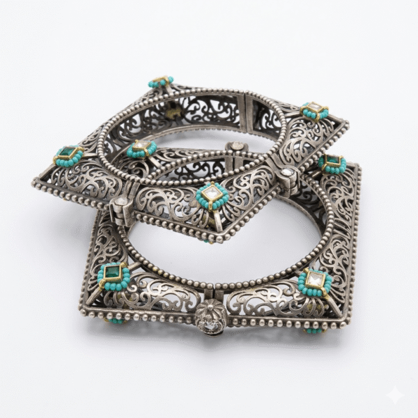 Close-up of two stacked artisan square Kada bracelets made of antique silver, featuring intricate openwork filigree, turquoise beads, and square-cut emerald-green Kundan stones