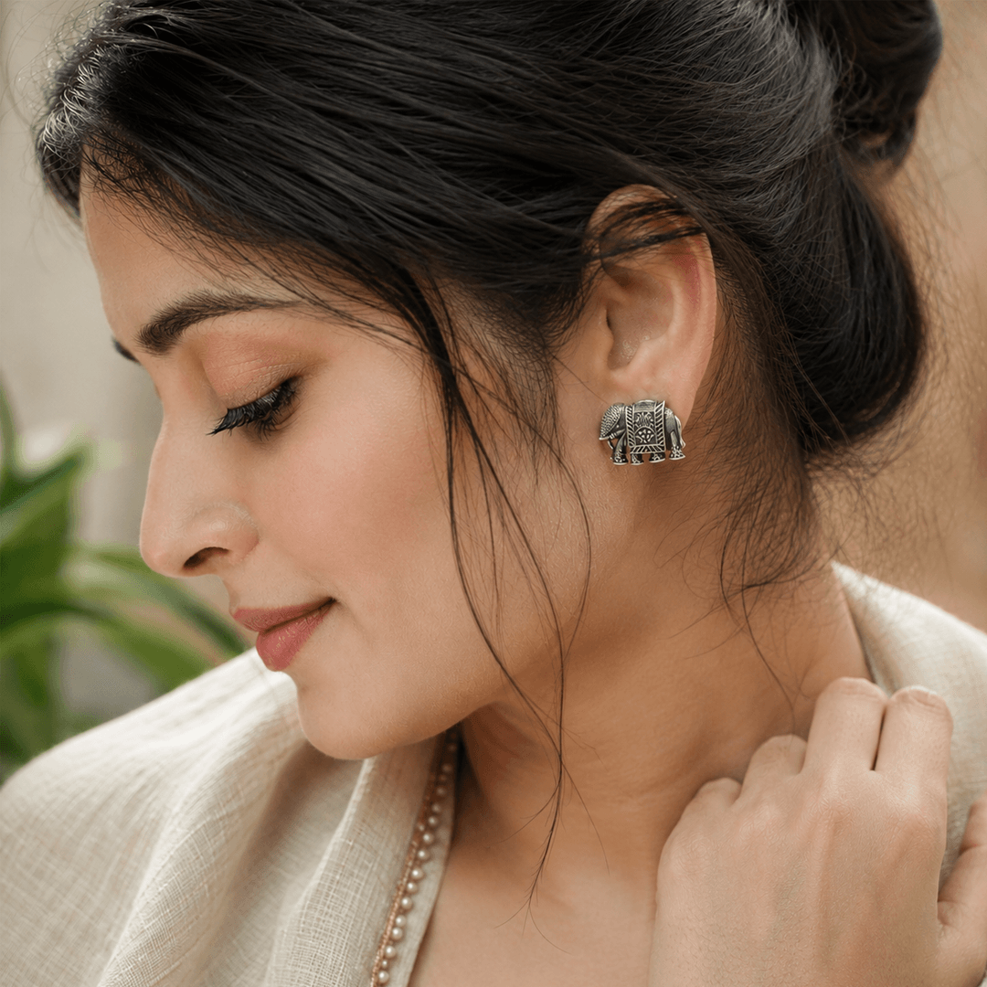 Beautiful woman wearing German silver elephant stud earrings