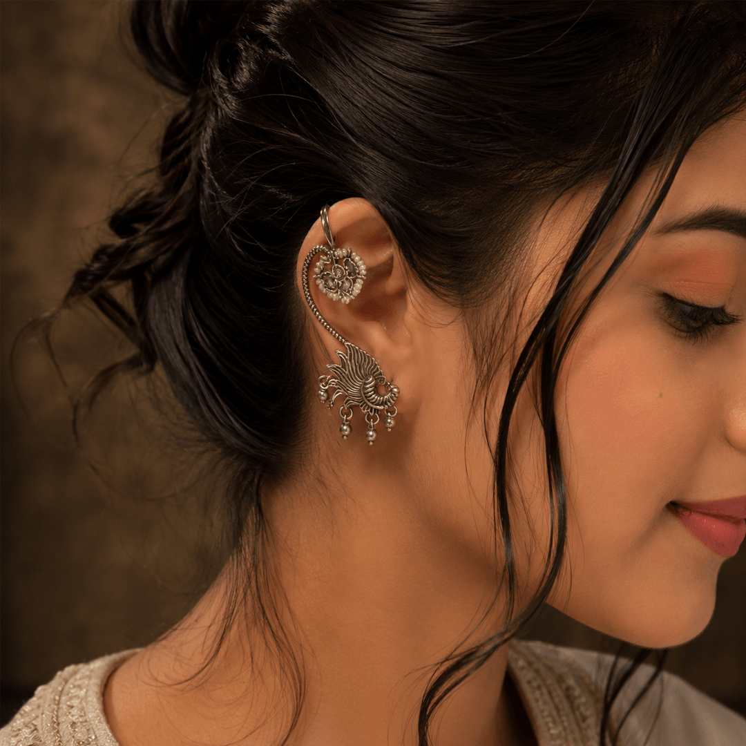 Woman wearing german silver peacock earcuff with floral upper clip