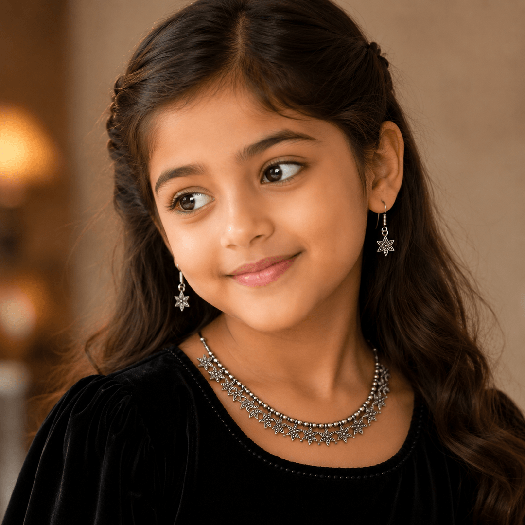 Young girl wearing silver floral necklace with matching dangling earrings
