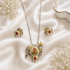 Traditional German silver nandi pendant necklace set with multicolor stones, pearl detailing, and matching stud earrings on white satin background.