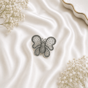 German silver oxidised butterfly ring with intricate filigree design on white satin background