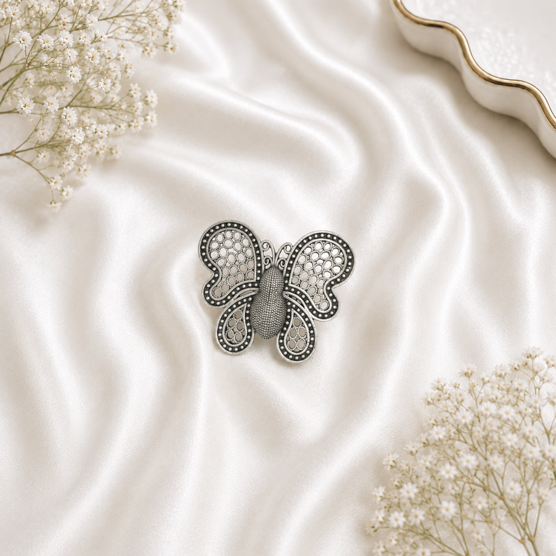 German silver oxidised butterfly ring with intricate filigree design on white satin background