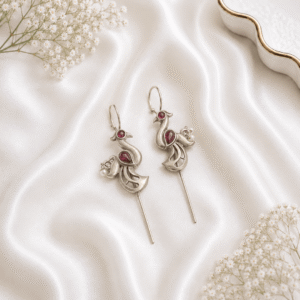 A pair of intricate, artisan-crafted peacock-shaped ear cuffs made of German silver