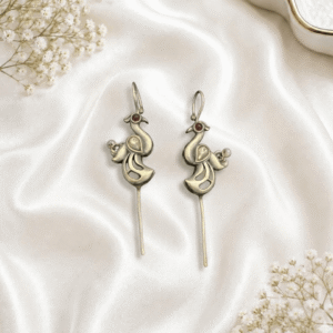 A pair of intricate, artisan-crafted peacock-shaped ear cuffs made of German silver