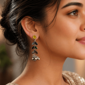 A woman wearing sophisticated, long drop earrings featuring a line of white multi-like ovals ending in a cluster of small silver-toned spheres.