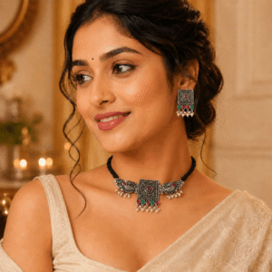 Model wearing an oxidized silver choker necklace with multi beads, square pendant, pearl drops, and matching earrings with traditional saree look.