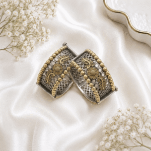 Pair of premium oxidized German silver floral cuff kada bangles with dual-tone antique gold detailing on a white satin background.