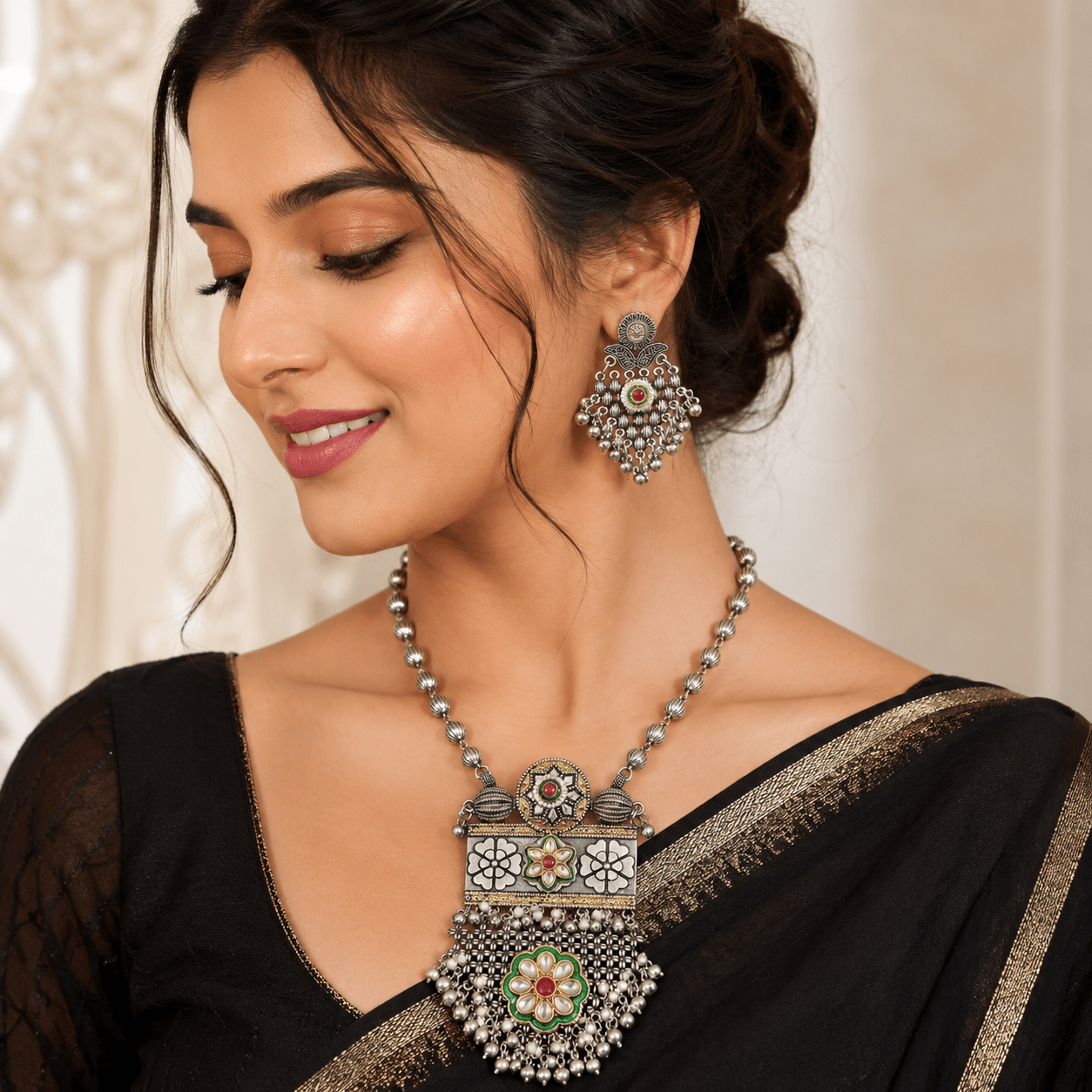 Woman wearing a premium oxidized silver necklace set featuring a floral pendant with ghungroo tassels and matching oxidized earrings.