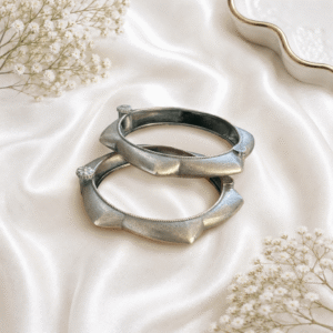 Pair of premium German silver plain kada bangles with an antique matte finish displayed on a white satin background.
