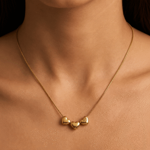 Gold plated triple heart charm necklace worn on neck