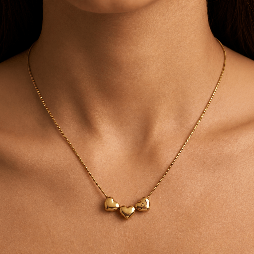 Gold plated triple heart charm necklace worn on neck