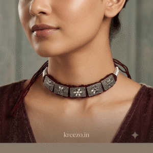 Woman wearing a handmade oxidised silver choker necklace with floral engraved square charms and adjustable thread.