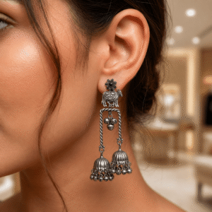 Oxidised silver elephant jhumka earrings with floral stud, dual dome danglers, ghungroo beads and antique ethnic design worn on ear.
