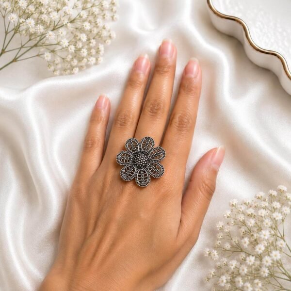 and wearing an intricate oxidized silver filigree floral statement ring from Kreezo,