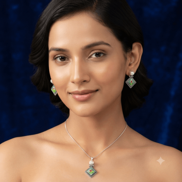 Woman wearing a premium silver finish floral pendant necklace with matching pearl stud earrings featuring a green floral design.
