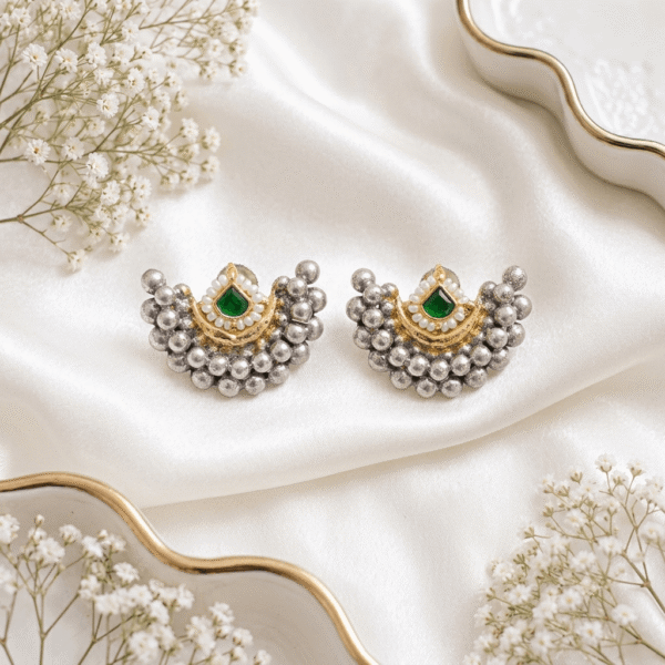 A pair of Kreezo German silver crescent-shaped stud earrings featuring clustered silver beads, a gold-tone crescent motif, and a central square ruby green stone.