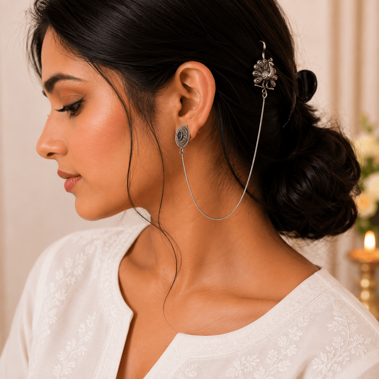 Woman wearing premium German silver peacock chain earrings connected to a decorative hair hook for an elegant ethnic look.