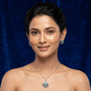 A young woman wearing a traditional silver necklace and earring set featuring green stone gajara style design