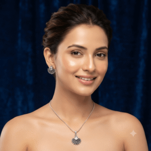A young woman wearing a traditional silver necklace and earring set featuring white stone gajara style design