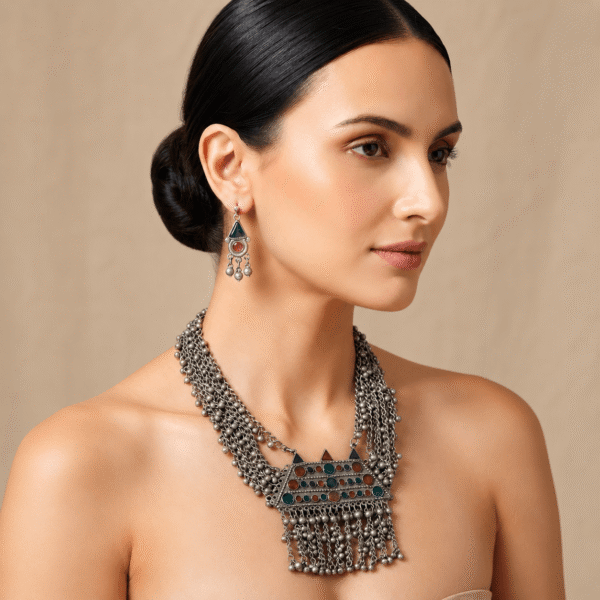 Model wearing Kreezo handcrafted silver multistrand necklace adorned with red, green, and blue stones and matching earrings.