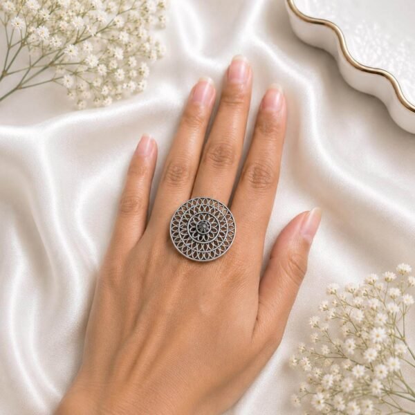 and wearing an intricate oxidized silver filigree floral statement ring from Kreezo,