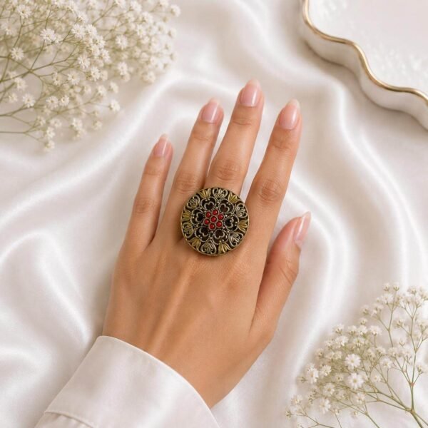 statement ring with intricate floral design and red stone detailing
