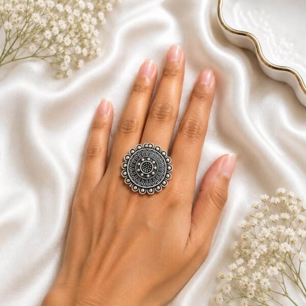 and wearing an intricate oxidized silver filigree floral statement ring from Kreezo,