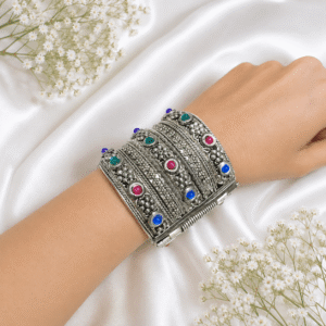 silver broad cuff bracelet with intricate floral detailing and blue, pink and green stones
