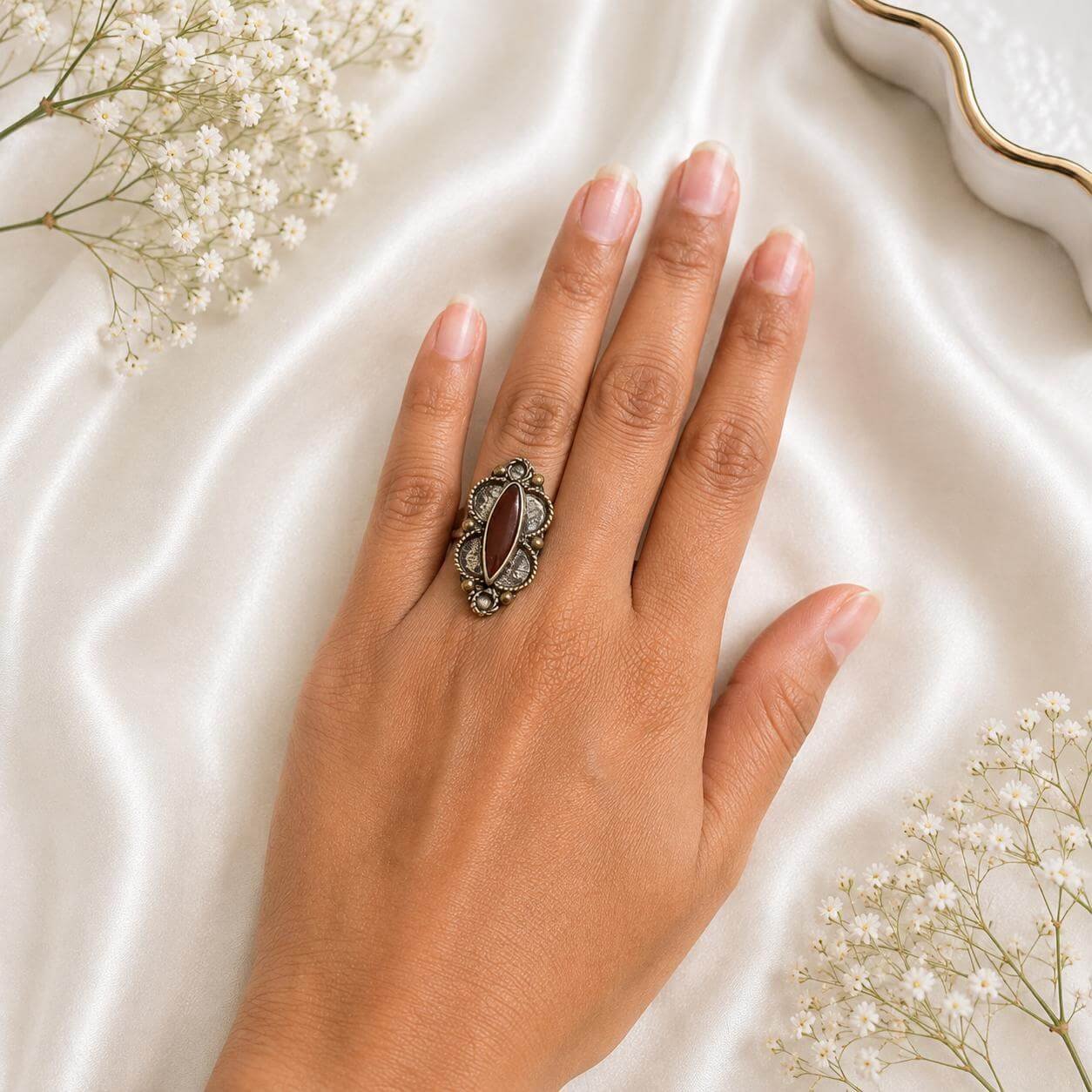 Oxidised silver statement ring with a maroon oval stone and intricate floral detailing